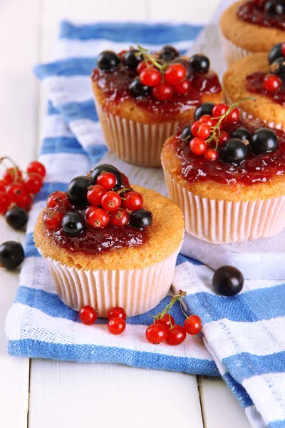 Muffins saborosos com bagas na mesa de madeira branca — Fotografia de Stock