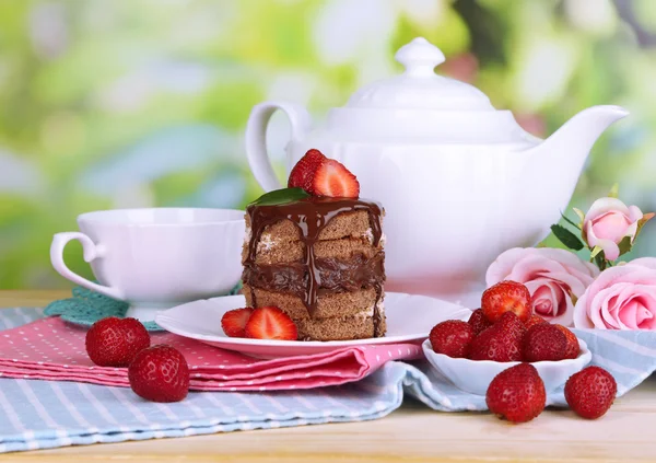 Chocolate cake met aardbei op houten tafel op natuurlijke achtergrond — Stockfoto