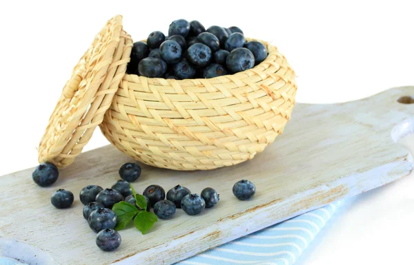 Blueberries in wooden basket on board on napkin isolated on white — Stock Photo, Image