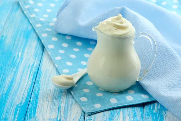 Saure Sahne im Krug auf dem Tisch in Großaufnahme — Stockfoto