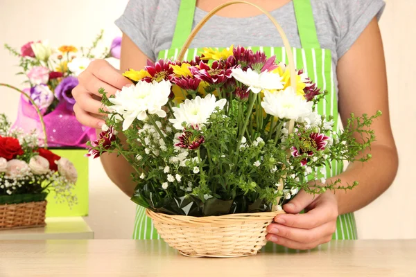 Florista faz buquê de flores em cesta de vime — Fotografia de Stock