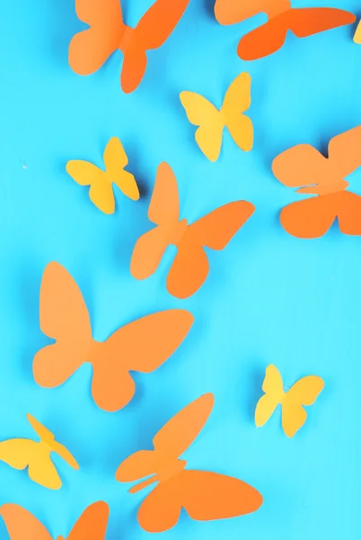 Borboletas de papel no fundo da placa de madeira azul — Fotografia de Stock