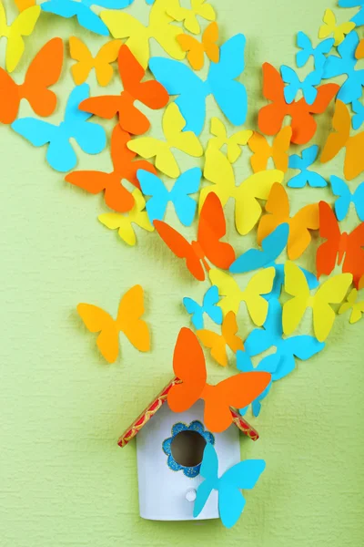 緑の壁の背景にネスト ボックスから飛ぶ紙蝶 — ストック写真