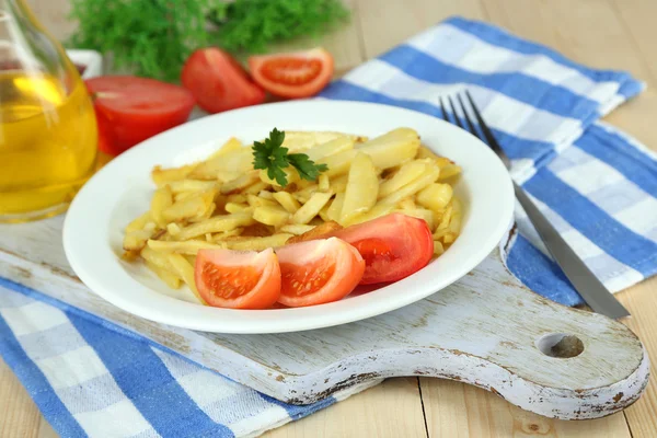 Rumiany smażone ziemniaki na tabliczce na drewniany stół szczegół — Zdjęcie stockowe