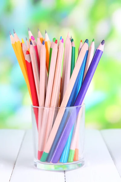 Kleurrijke potloden in glas op houten tafel op natuurlijke achtergrond — Stockfoto