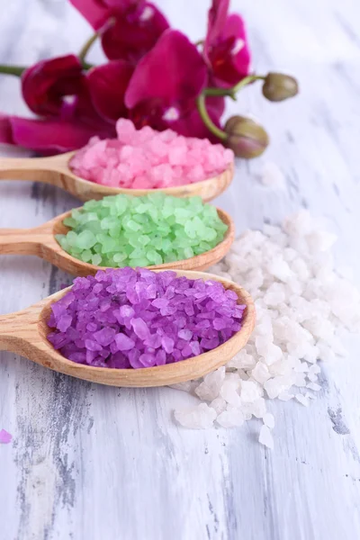 güzel çiçek ile natürmort orkide çiçek ve renk ahşap zemin üzerinde deniz tuzu ile tahta kaşıklar