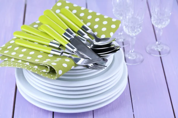 Καθαρίσει τα πιάτα στο ξύλινο τραπέζι σε φόντο χρώμα — Φωτογραφία Αρχείου
