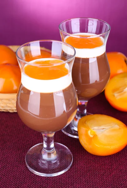 Dessert of chocolate and persimmon on table on purple background — Stock Photo, Image