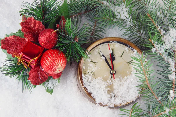 时钟与冷杉枝和雪下的圣诞装饰关闭 — 图库照片