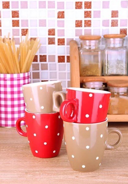 Copos na cozinha na mesa em mosaico telhas de fundo — Fotografia de Stock