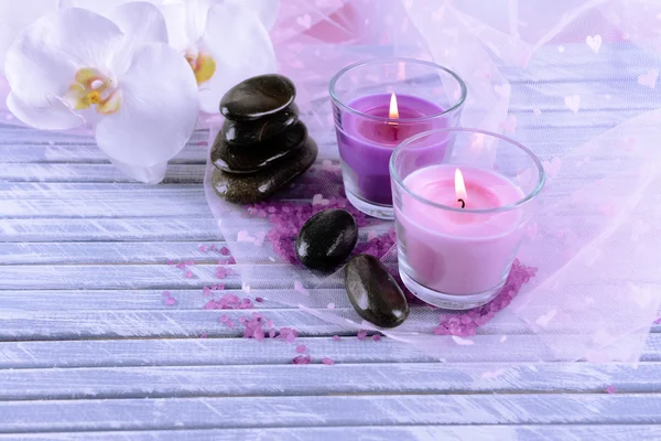 Красиві барвисті свічки та орхідеї, на кольоровому дерев'яному фоні — стокове фото