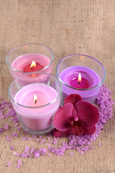 Composición con hermosas velas de colores, sal marina y flores de orquídea, sobre fondo de madera —  Fotos de Stock