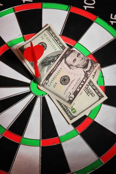 Money pierced by arrow on dartboard close up — Stock Photo, Image