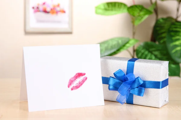 Gift with card for loved one on table on room background — Stock Photo, Image