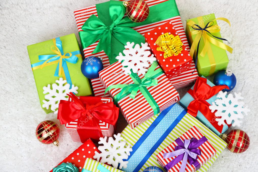 Many colorful presents with luxury ribbons on color carpet background