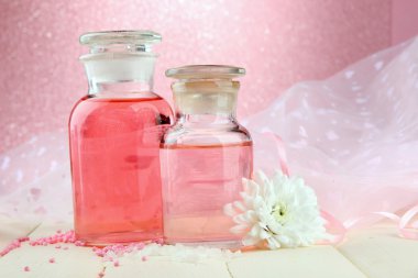 pembe bir arka plan üzerinde renkli özü ile cam şişe