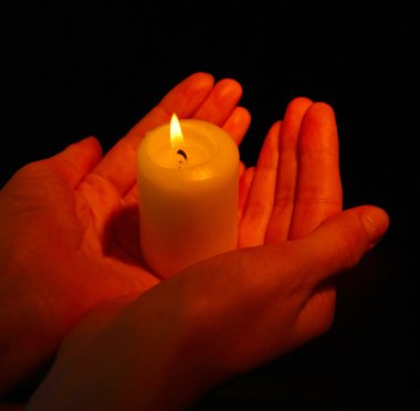 Siyah izole elinde yanan mum