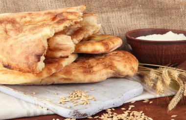 Pita ekmekler sivri ve un üstünde çul arka masada