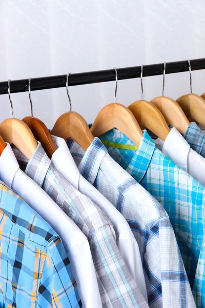 Men's shirts on hangers on light background — Stock Photo, Image