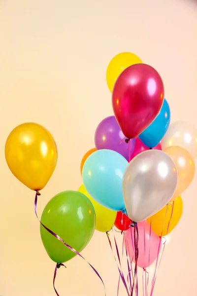 Veel heldere ballonnen op oranje achtergrond — Stockfoto