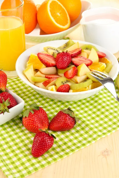 Χρήσιμο φρούτα σαλάτα από φρέσκα φρούτα και τα μούρα σε μπολ σε χαρτοπετσέτα σε κοντινό πλάνο ξύλινο τραπέζι — Φωτογραφία Αρχείου