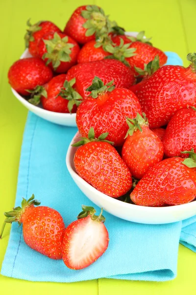 Fresh strawberry in bowl on green wooden background — Stock Photo, Image