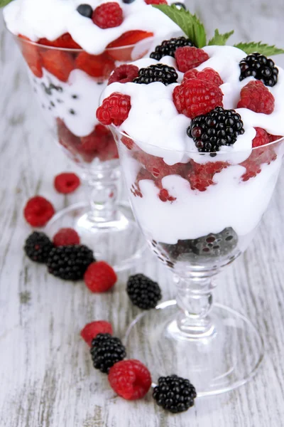 Přírodní jogurt s čerstvým ovocem na dřevěné pozadí — Stock fotografie