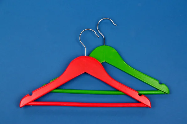 Colorful clothes hangers on blue background — Stock Photo, Image