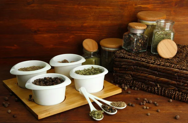 Surtido de especias en cucharas blancas y cuencos, sobre fondo de madera — Foto de Stock