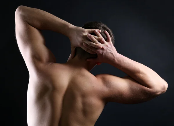 Schöner junger muskulöser Sportler, auf dunklem Hintergrund — Stockfoto