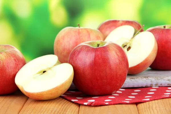 Manzanas maduras sobre mesa de madera, sobre fondo brillante — Foto de Stock