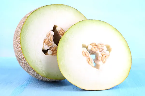 Ripe melons on wooden table on blue background — Stock Photo, Image