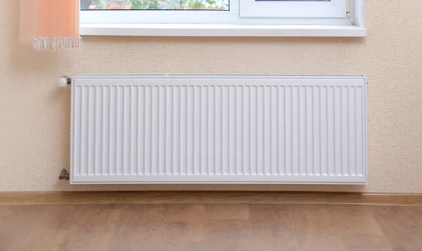 Foto radiador de aquecimento sob janela — Fotografia de Stock