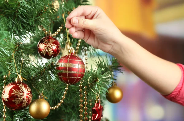 Decorating Christmas tree on bright background — Stock Photo, Image