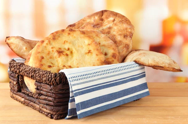 Pita breads in basket on table on bright background — Stock Photo, Image