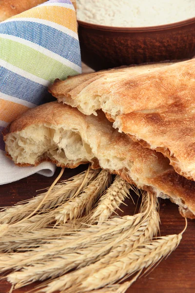 Pita brood met spikes en meel op tafel close-up — Stockfoto