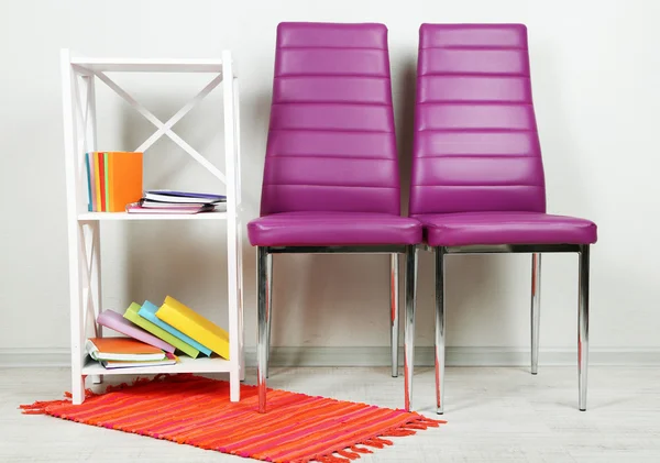 Mooi interieur met moderne kleur stoelen, boeken op houten voet, op de muur achtergrond — Stockfoto