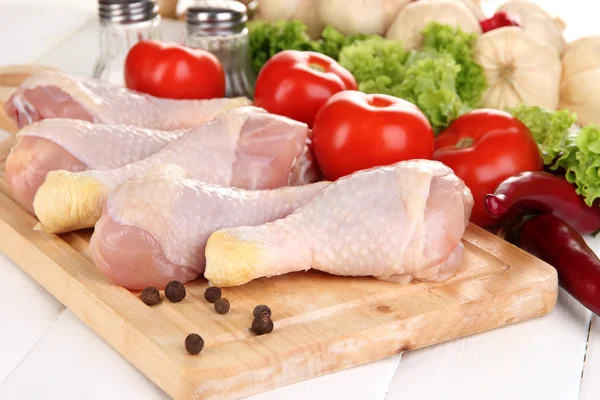 Raw chicken legs on wooden board close up — Stock Photo, Image