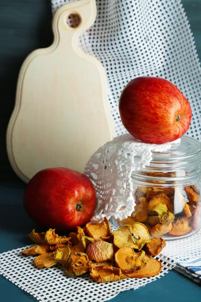 Manzanas secas en tarro de vidrio, sobre fondo de madera de color —  Fotos de Stock