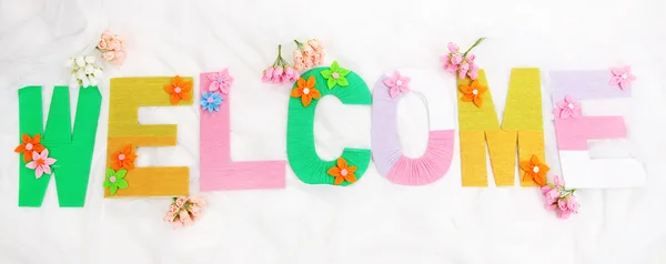 Word Welcome created with brightly colored knitting yard on fabric background — Stock Photo, Image