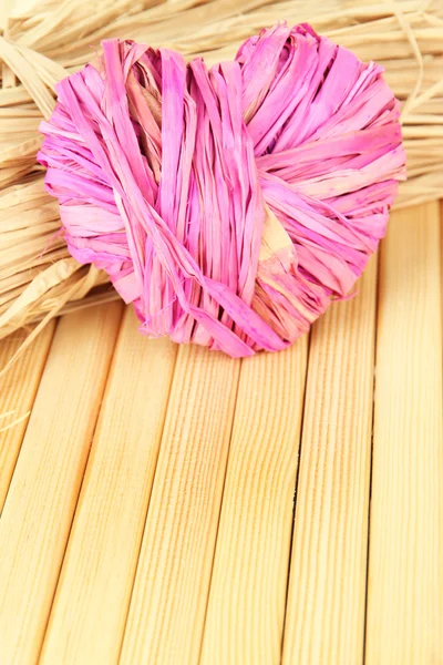 Palha decorativa para feito à mão e coração de palha, no fundo de madeira — Fotografia de Stock