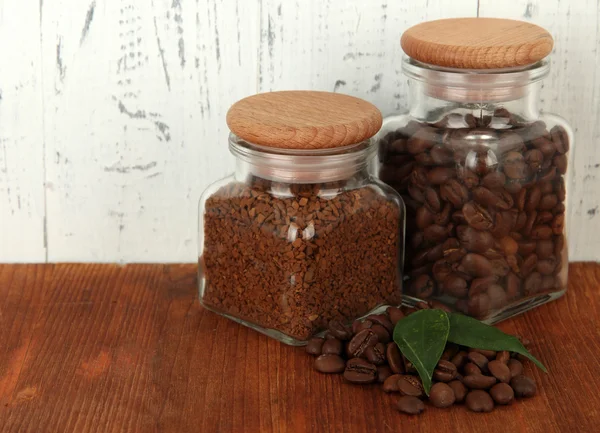 Jars of different coffee on table on wooden background — Stock Photo, Image