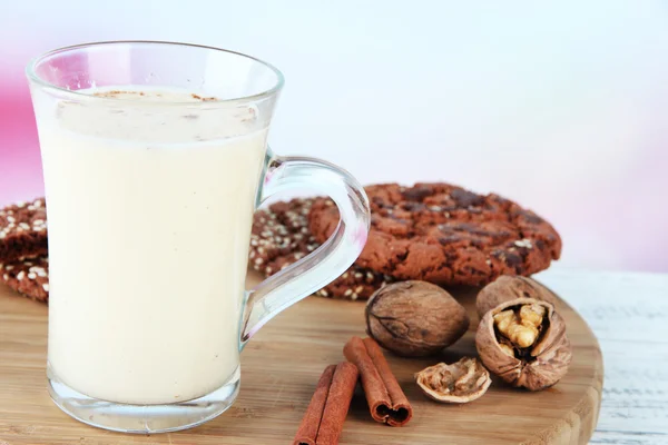 Pohár vaječný likér se skořicí a soubory cookie v tabulce na světlé pozadí — Stock fotografie