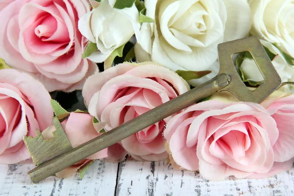 Key of happiness. Conceptual photo. Key with roses, on light wooden background — Stock Photo, Image