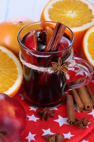 Vino caliente fragante en vaso en servilleta y mesa de madera de cerca —  Fotos de Stock