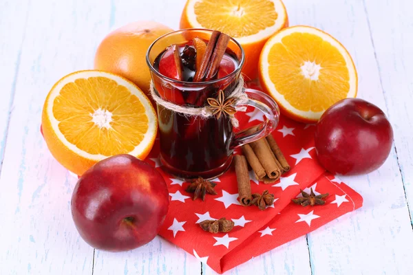 Fragrant mulled wine in glass on napkin and wooden table close-up — Stockfoto