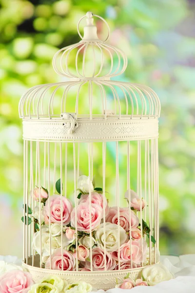 Hermosa jaula decorativa con hermosas flores, sobre fondo natural —  Fotos de Stock