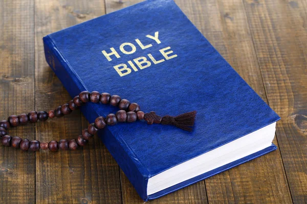 Bijbel met grensoverschrijdende op houten tafel close-up — Stockfoto