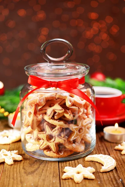 Deliciosas galletas de Navidad en tarro sobre mesa sobre fondo marrón — Foto de Stock