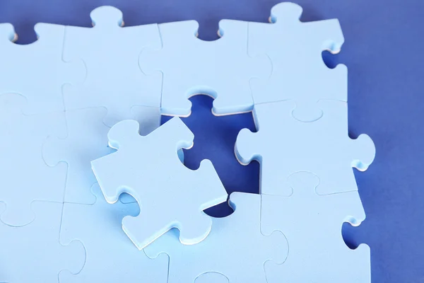 Laatste stuk van jigsaw puzzle, close-up, op blauwe achtergrond — Stockfoto